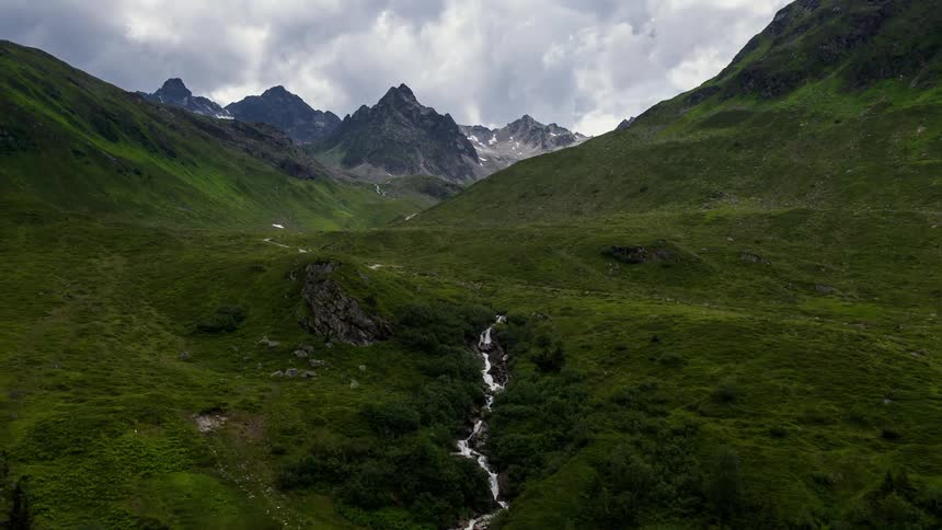 A stream runs through the green mountain