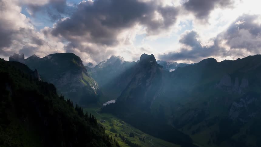 Clouds and sun shining through over mountains