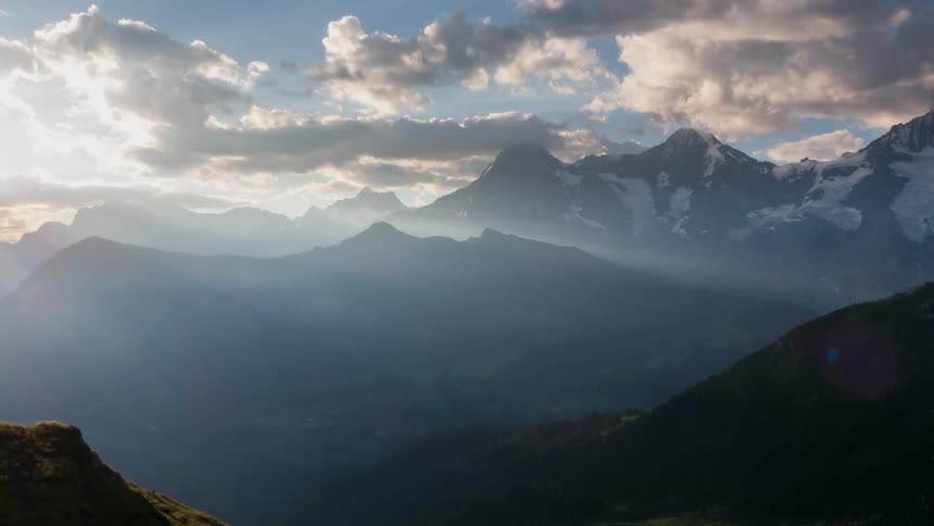 Clouds hang above the tall mountains