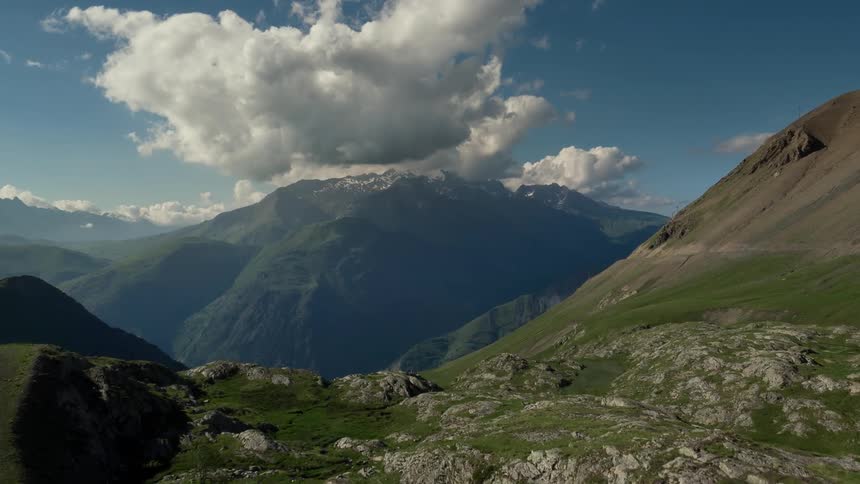 Clouds hang above a tall mountain