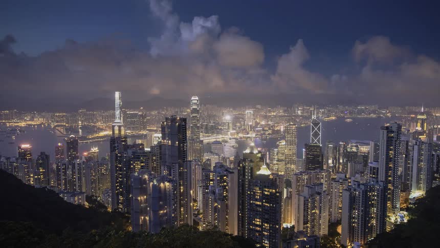 The large clouds roll over the city with many tall buildings