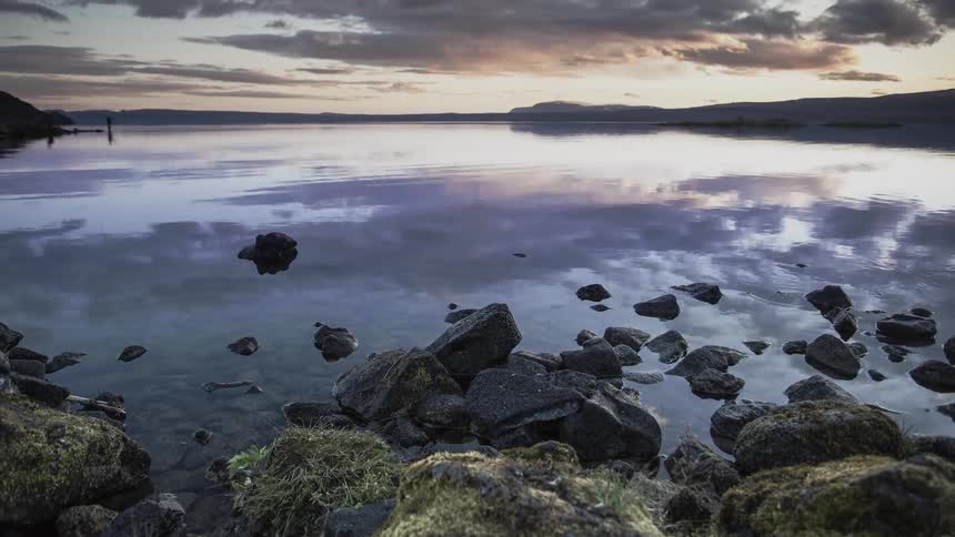 Clouds passing overhead are reflected in the water's surface