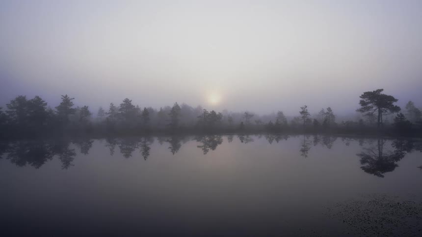 Time lapse of the fog rolling over a lake as the sun rises