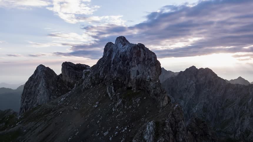 The sun is setting behind the mountains