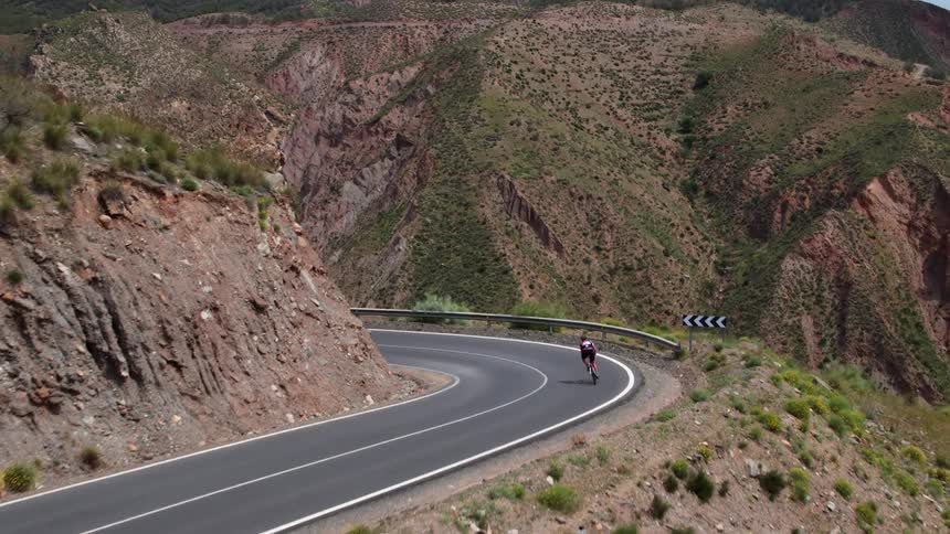 A person is riding their road bike along exposed rock scenery in the south of Spain