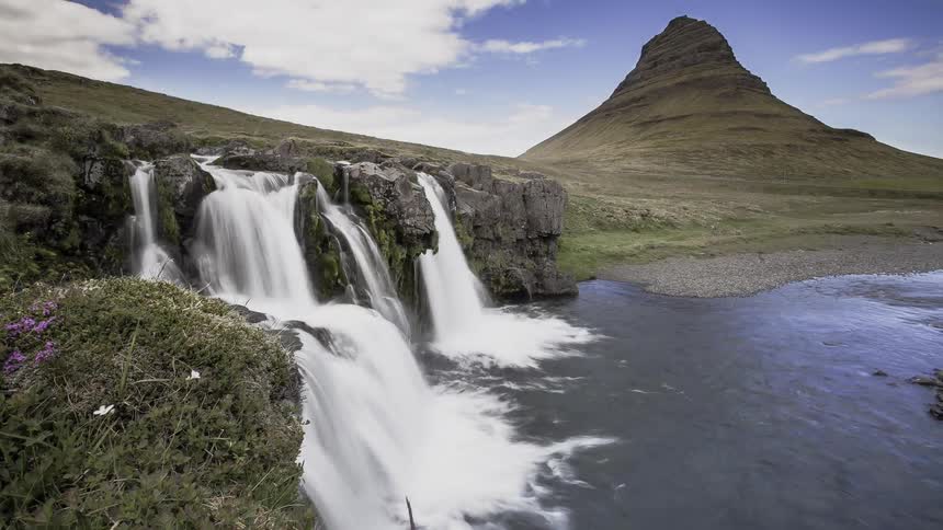 Water flows from the cliff into the river
