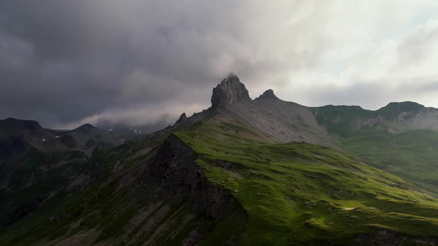 Clouds billow over mossy mountains