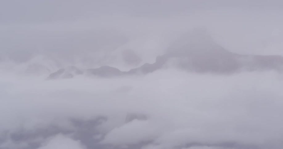 Think dense clouds covering a mountain top