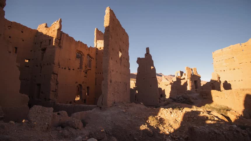 Clouds float over stone ruins in a desert