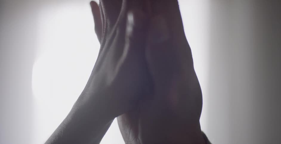A man and woman press their palms together and touch fingertips