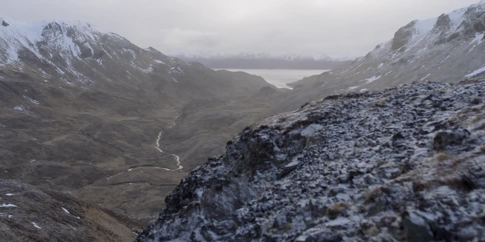Snow covers a rocky mountainside