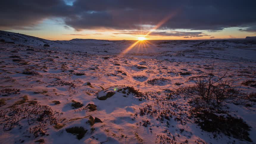 Sun setting over snowy plains