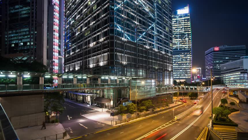 Busy traffic between modern skyscrapers at night