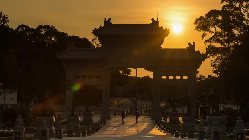 People walk through the traditional gate of Po Lin monastery
