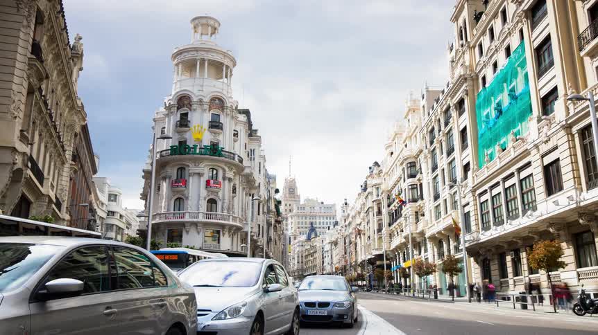 Cars and people travel along the city streets