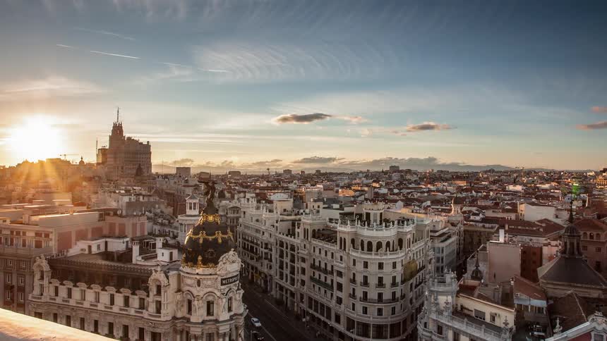 Vehicles travel on the Gran Via as the sun sets