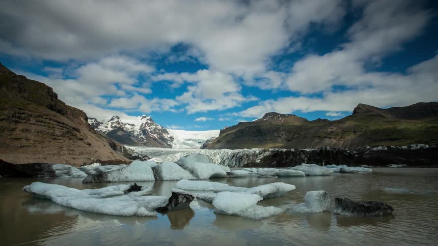 Clouds float over an icy mountain lake