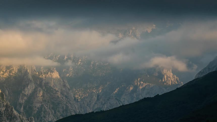 Clouds pass through tall mountains