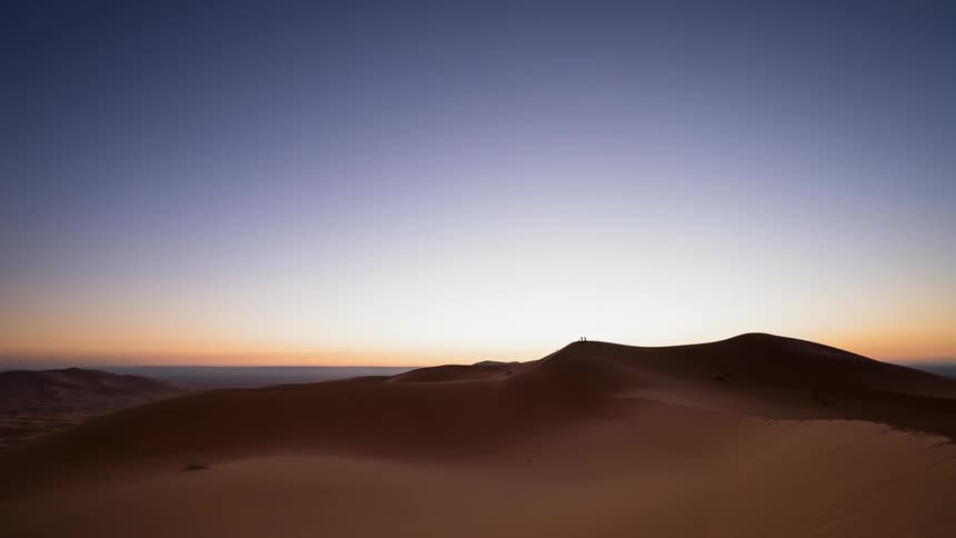 The sun rises over sand dunes in Sahara