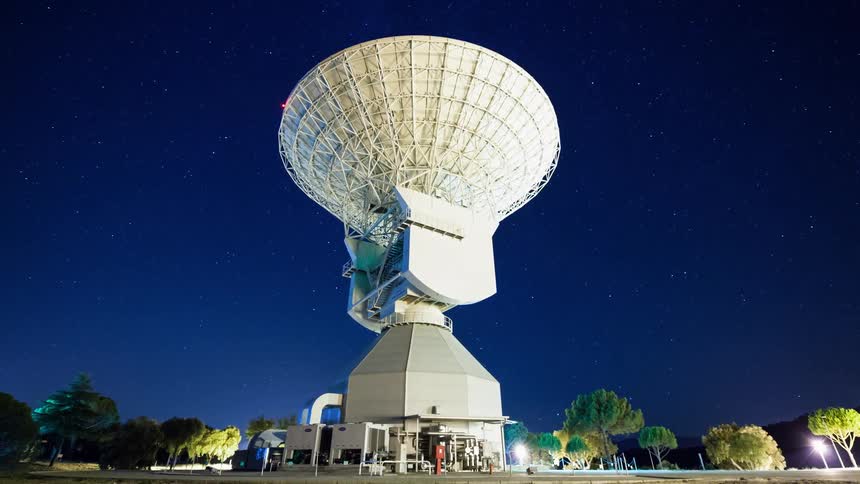 A large satellite towers into the night sky
