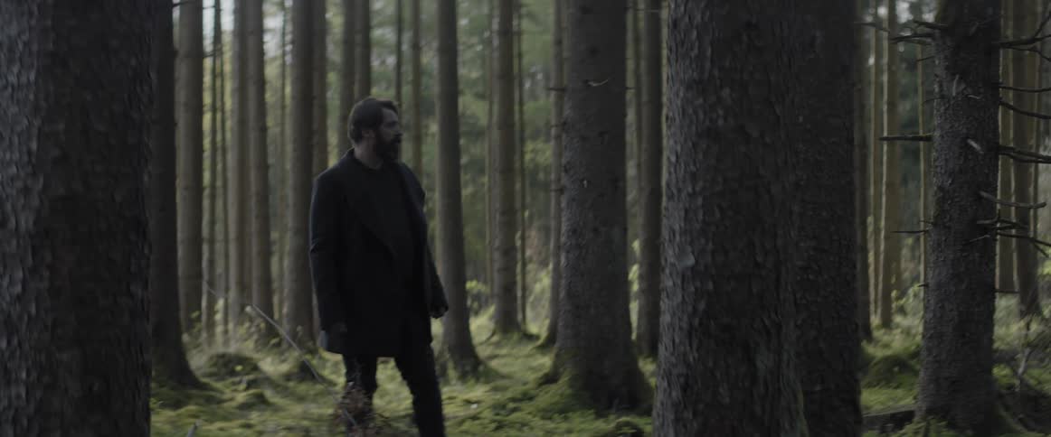 A man looks lost standing in the middle of the woods