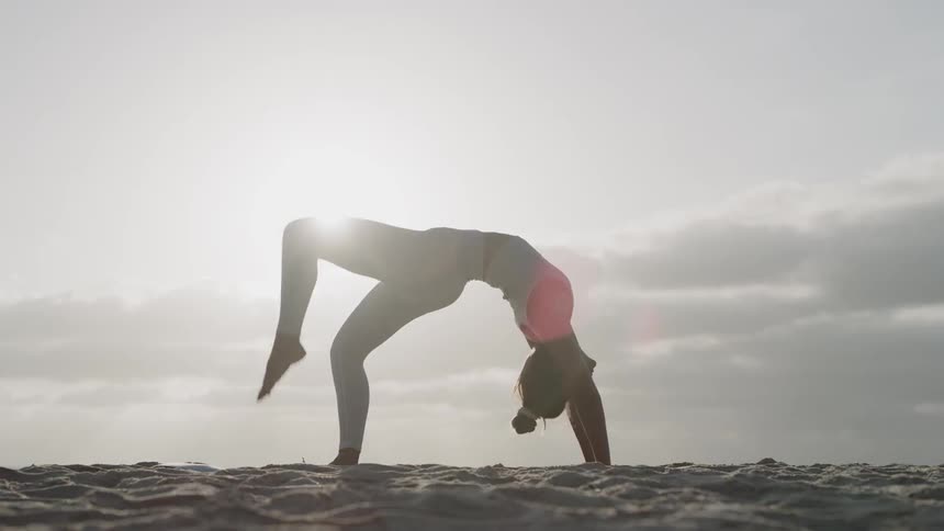 A woman stretches outside under the sun