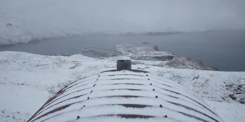A domed snow covered building above a harbor