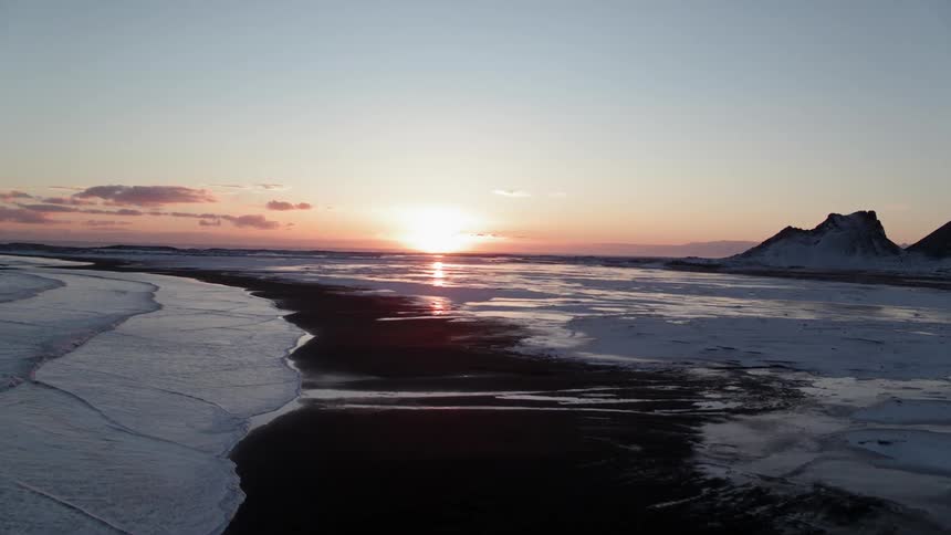 The sun sets over snow and mountains