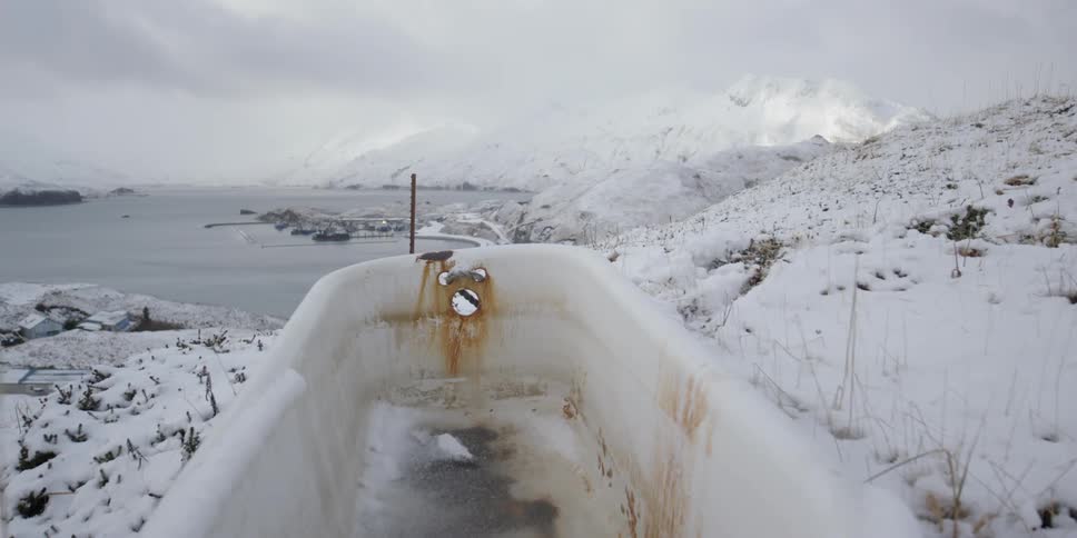 A bathtub sitting on top of a snowy hillside