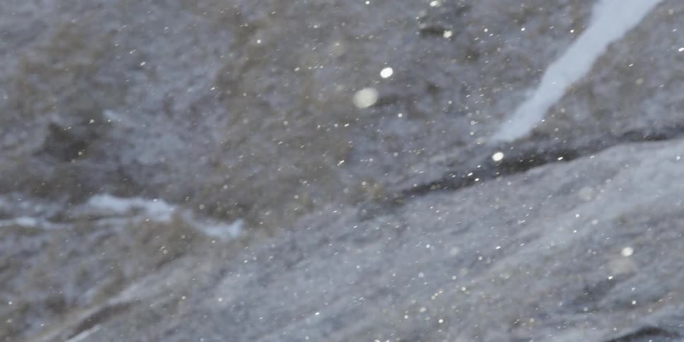 Snow is falling and sparkling in the sunlight