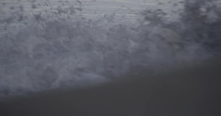 Ocean waves wash ashore at sunset