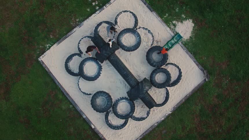 Kids play on large tires at a playground