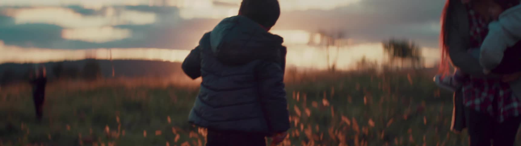 A kid picks two large squash from the ground