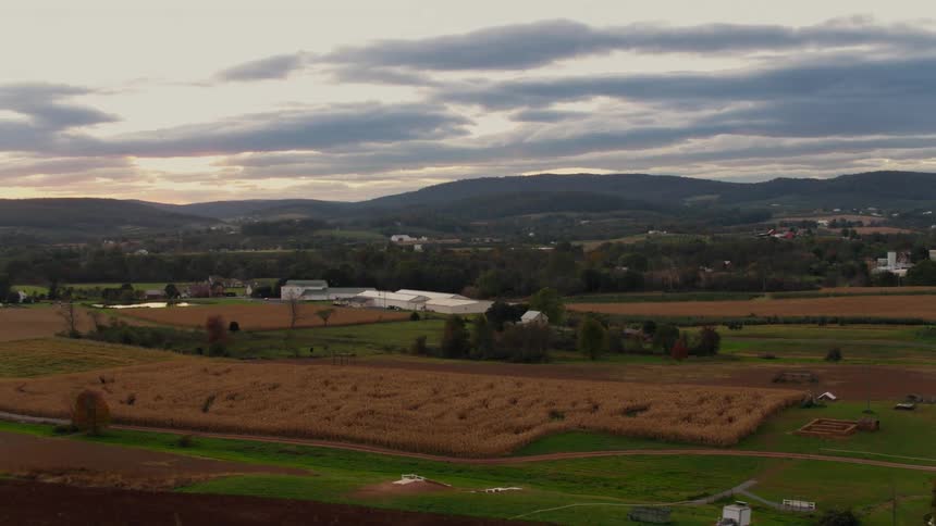 Clouds float over a rural farm at sunset