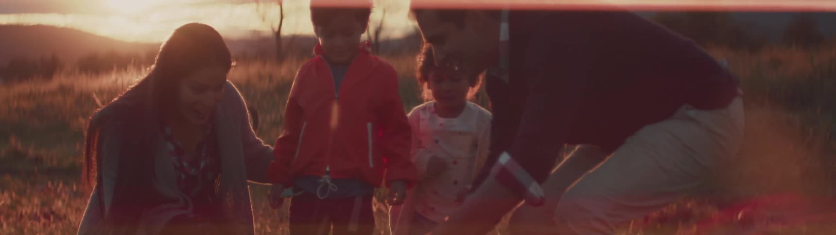 A family is walking through a field picking out a perfect pumpkin