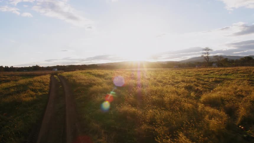 The sun sets over a rural field