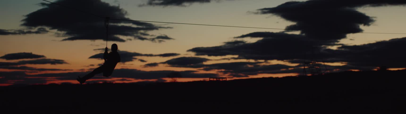 Someone is zip lining at sunset