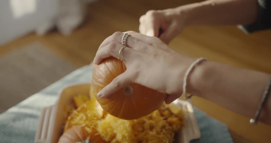 Woman carves a pumpkin at home