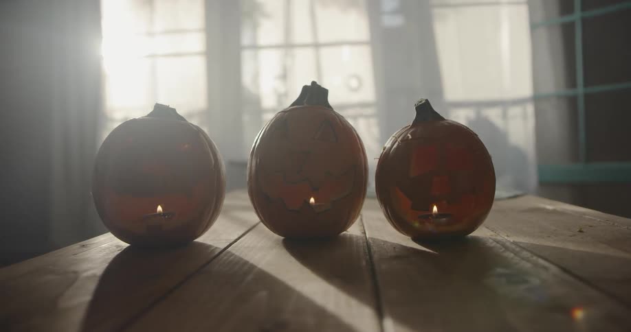 Candles burn inside carved pumpkins