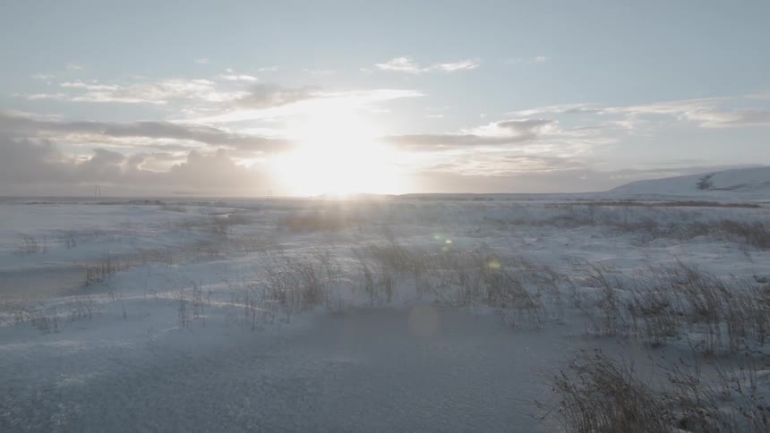 The sun rises over a snowy field
