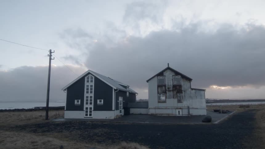 Clouds hover over rural buildings at sunset