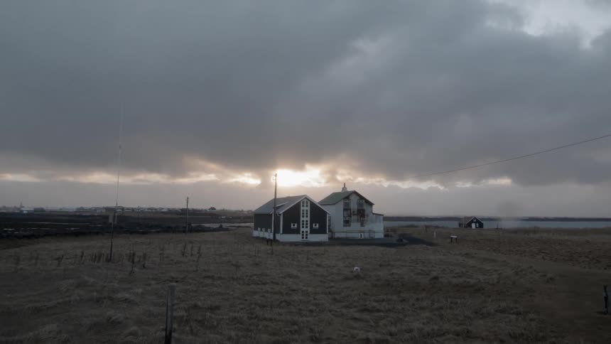 Clouds float over a rural building at sunset