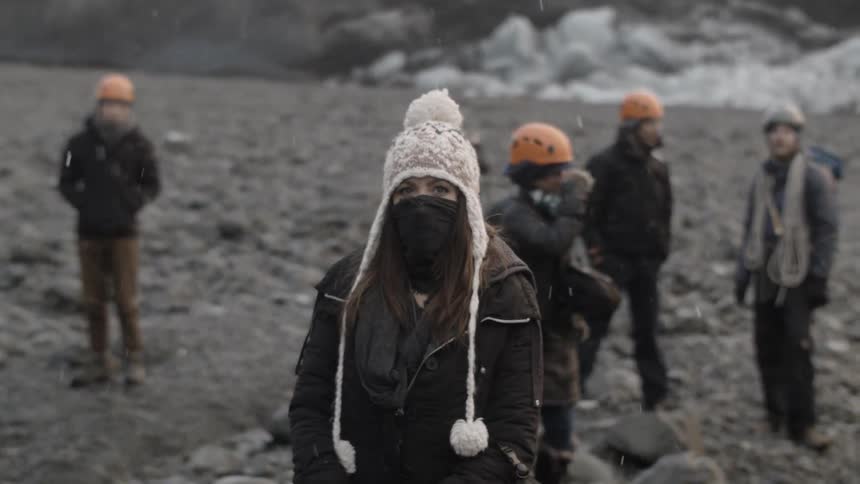 People stand in mountains while it snows