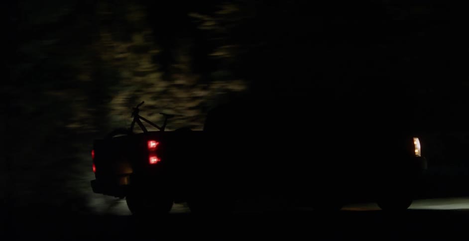 A truck drives in a dark area at night