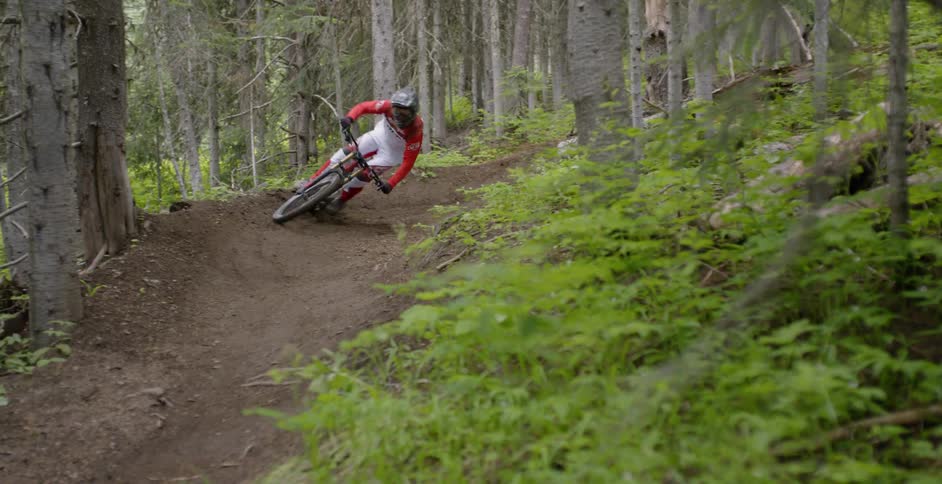 A person rides a mountain bike around a turn on a dirt trail