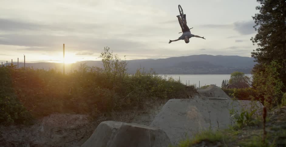 Mountain biker does backflip no hander at sunset
