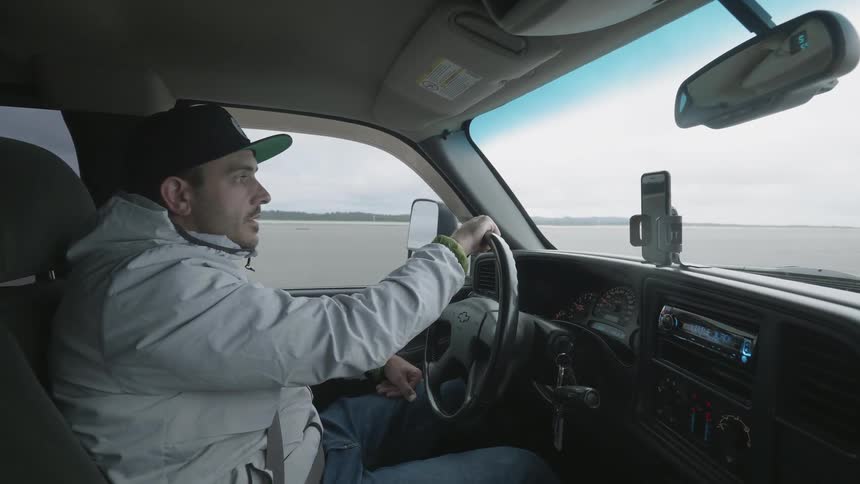 A man is looking around while driving his truck