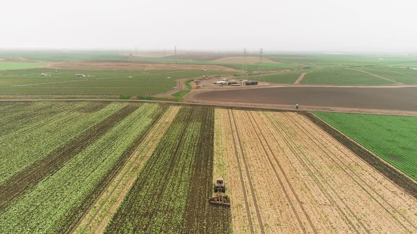 A tractor plows the crop field