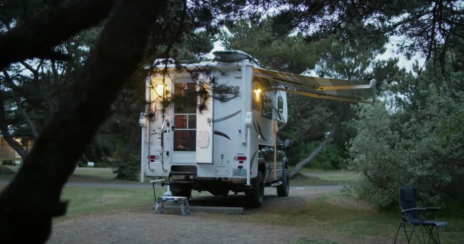 Camper with lights on parked in a campground