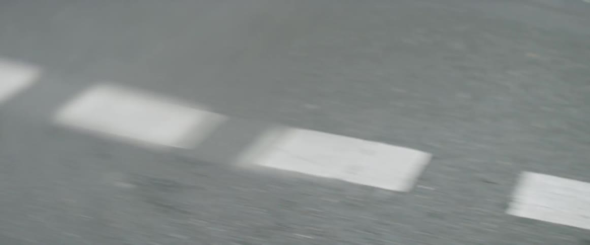 Cracks in an asphalt road with dashed white lines